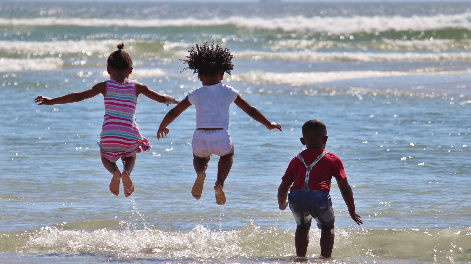 children jumping at beach